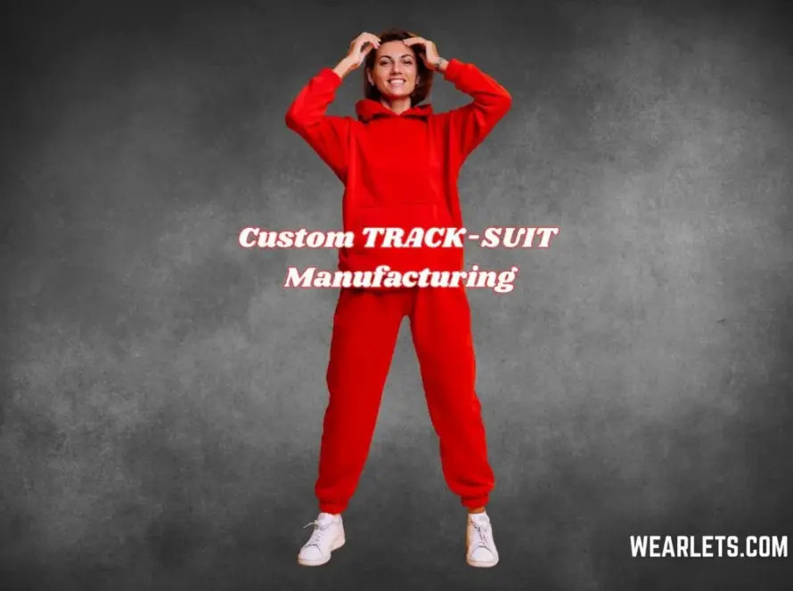 Person in a red tracksuit standing against a neutral gray backdrop, posing confidently — custom tracksuit manufacturing by Wearlets