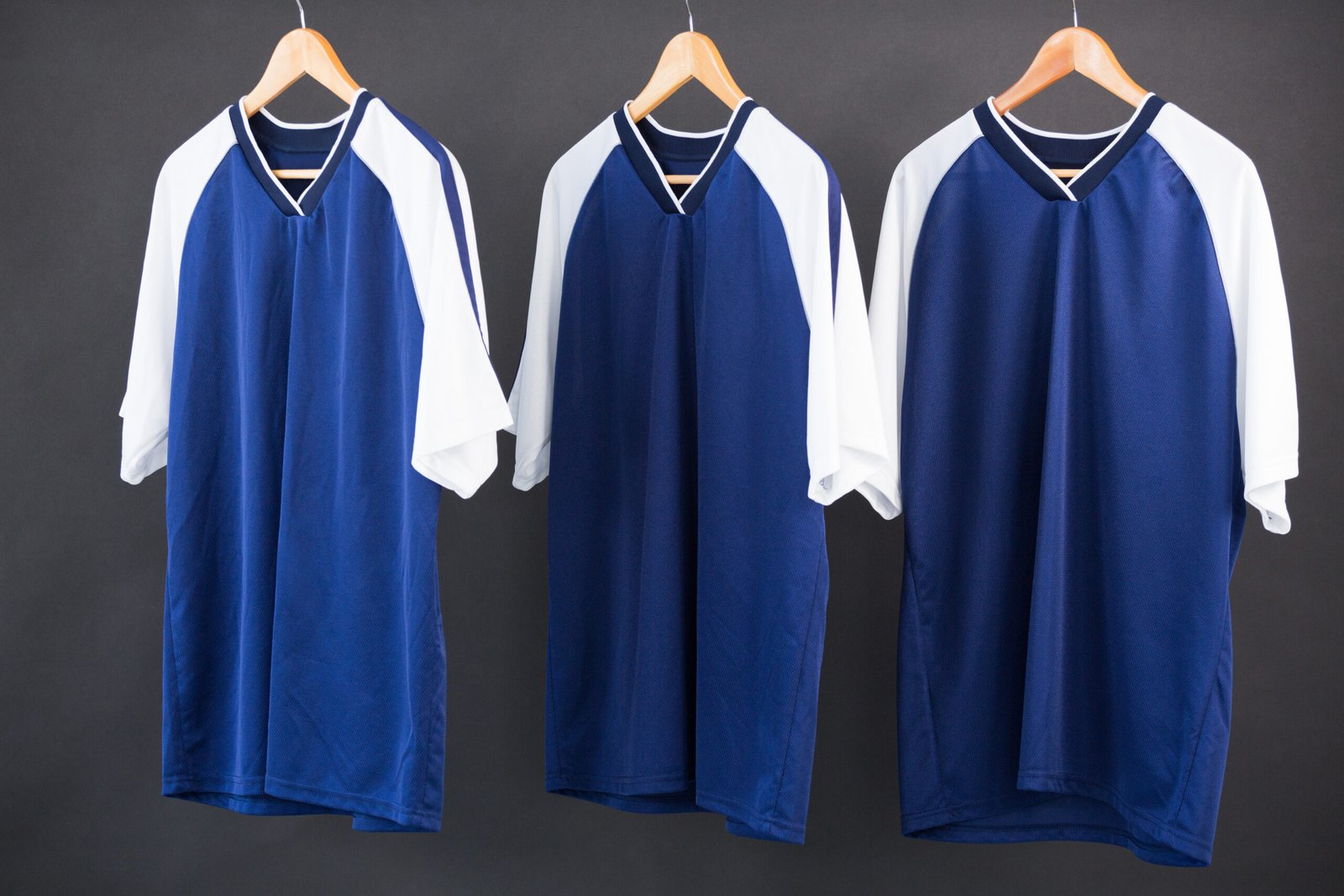 Close-up of custom sports jerseys hanging on rack — wholesale sports uniform manufacturer quality check