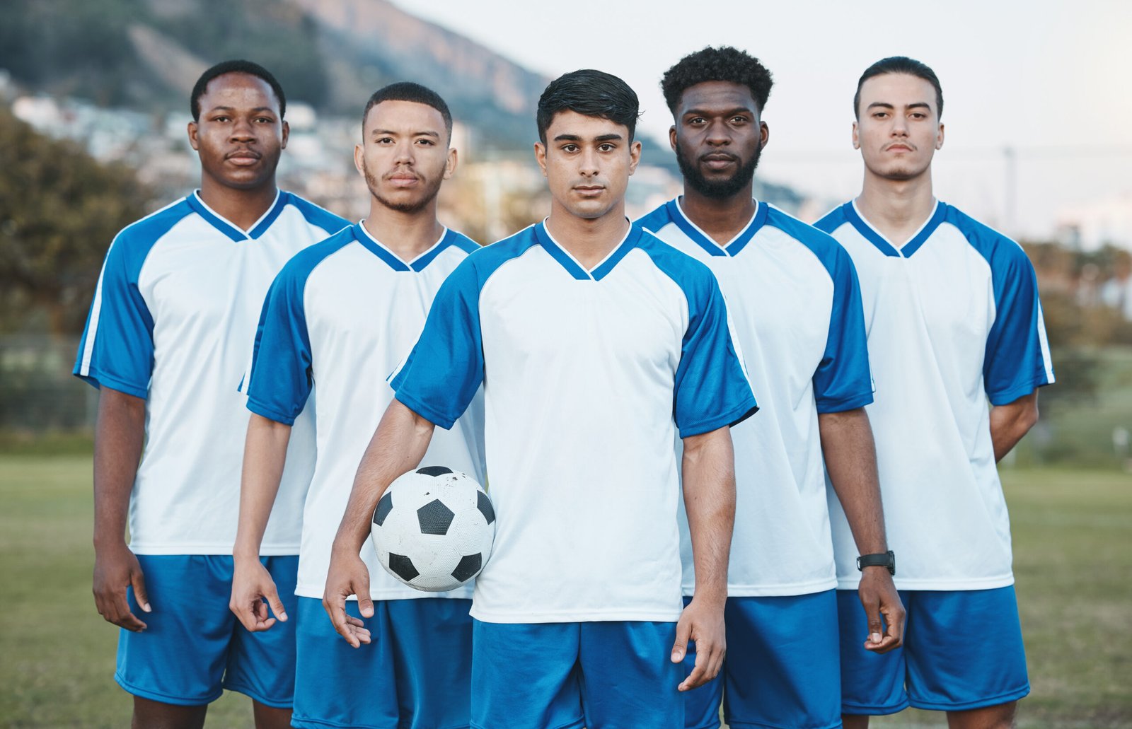 Custom football team posing in matching uniforms — bulk team uniform manufacturer USA | Wearlets
